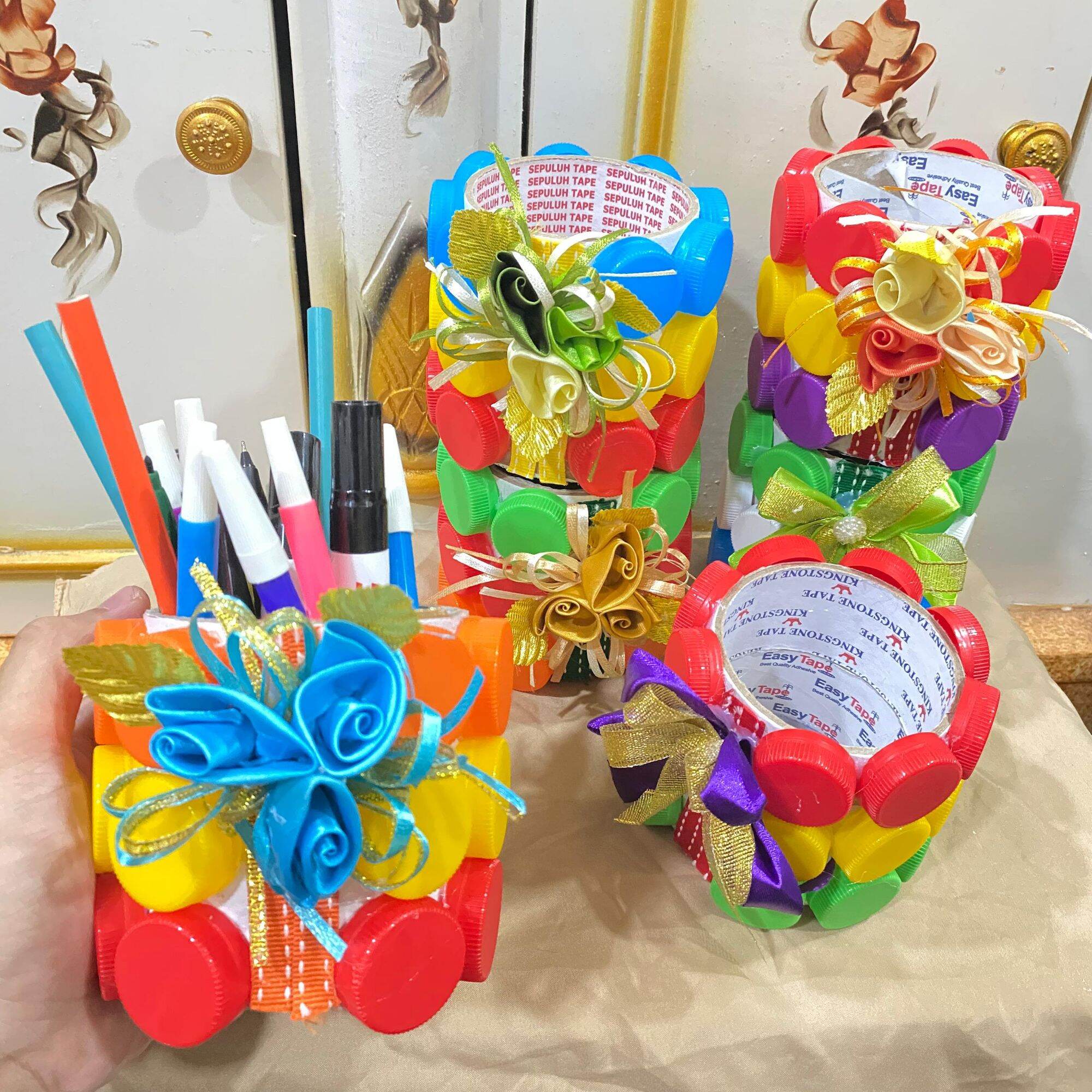Tempat penyimpanan alat tulis dari tutup botol warna dan bekas lakban